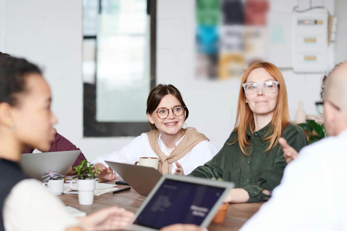 Grupo multigeneracional de profesionales en México colaborando en un entorno corporativo diverso.
