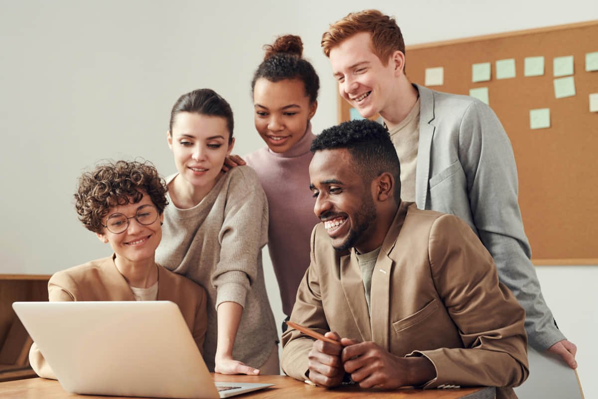 Trabajo colaborativo en digitalización de procesos Equipo pequeño trabaja con laptops y seguimiento de procesos digitales.
