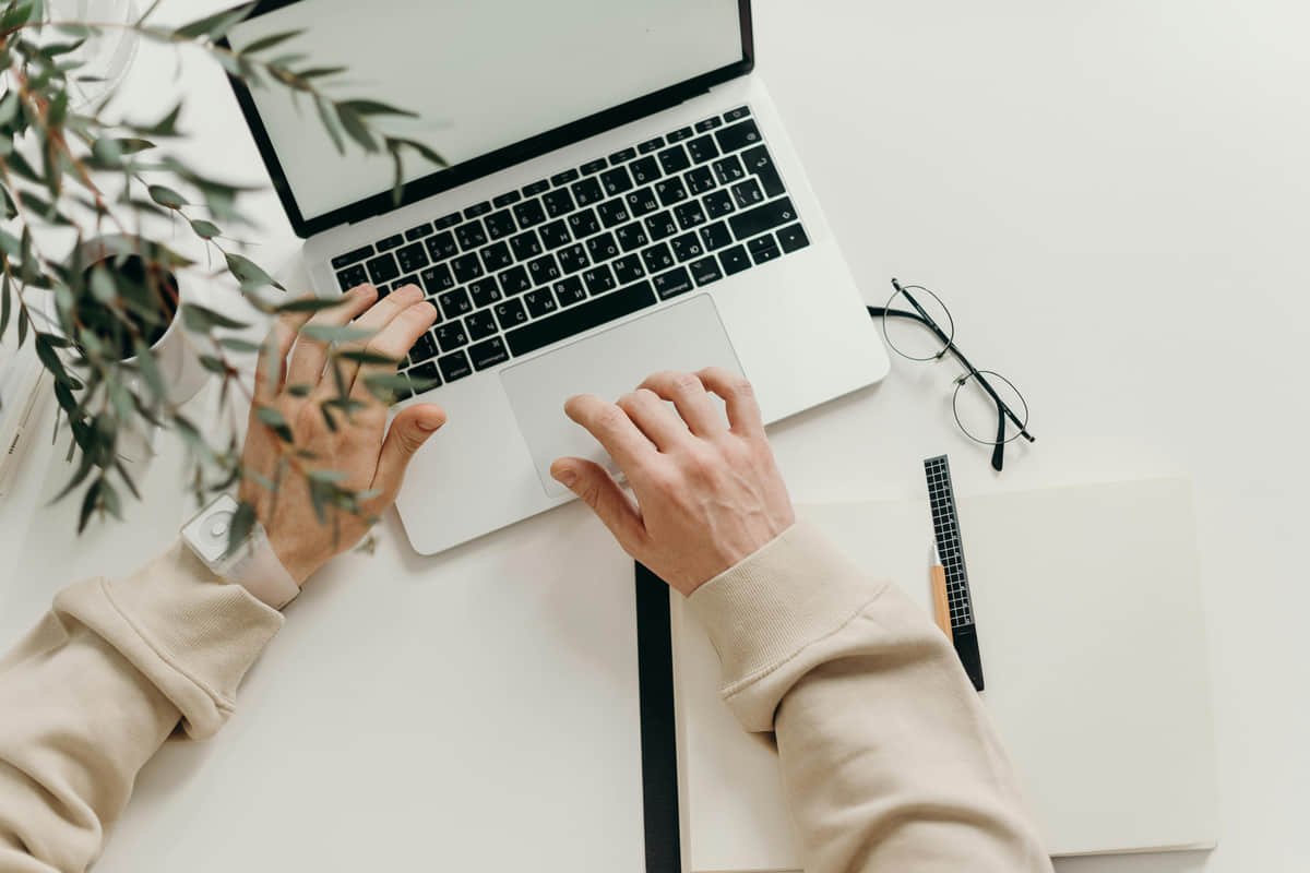 En 2026, la economía gig ofrece una alternativa real y rentable al empleo tradicional en México. Profesional independiente trabajando en su laptop desde una cafetería moderna, simbolizando la economía gig.