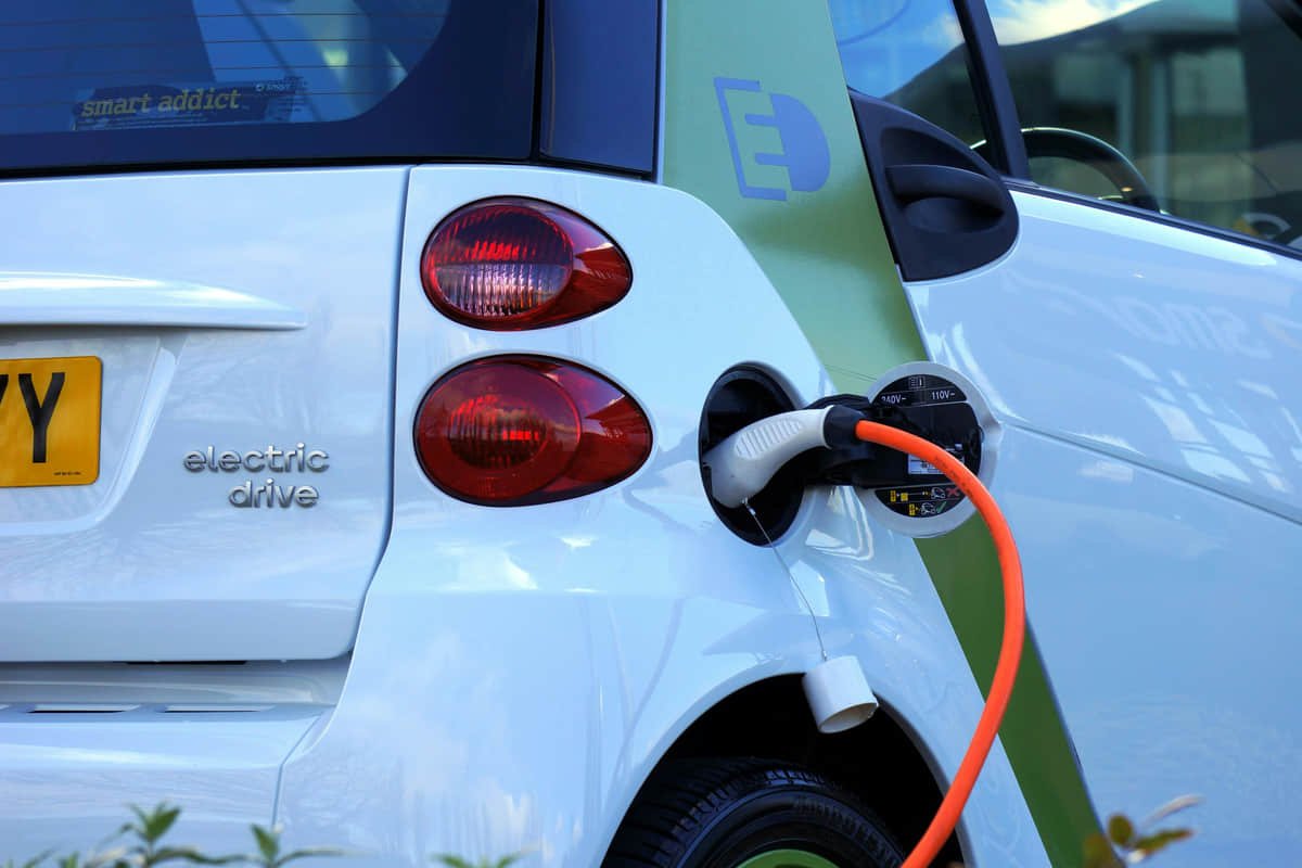 Revisión técnica de componentes Técnico revisa módulos eléctricos y equipo de prueba en una estación de trabajo.