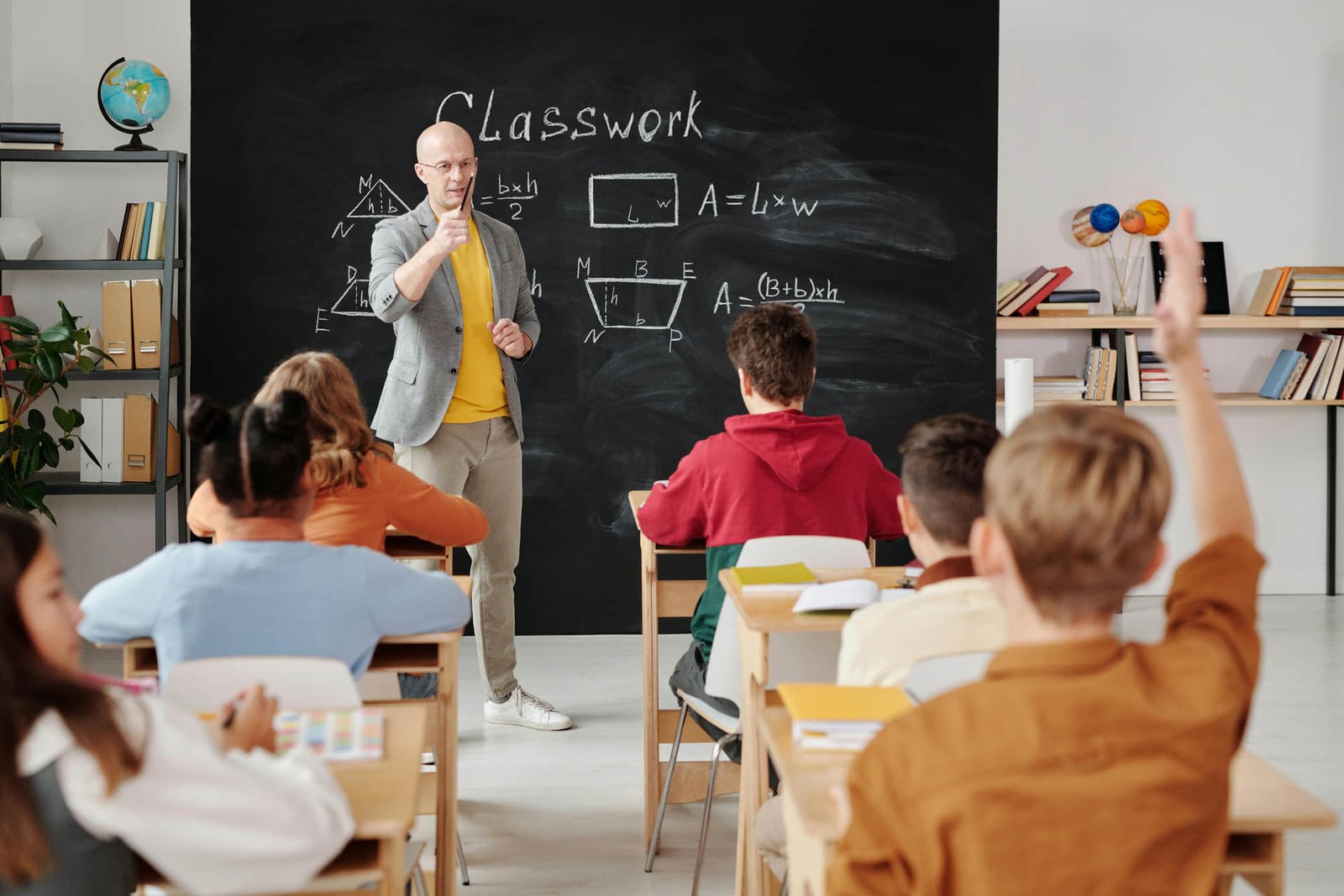 Professional reviews short courses and certifications on a laptop while taking notes in a notebook.