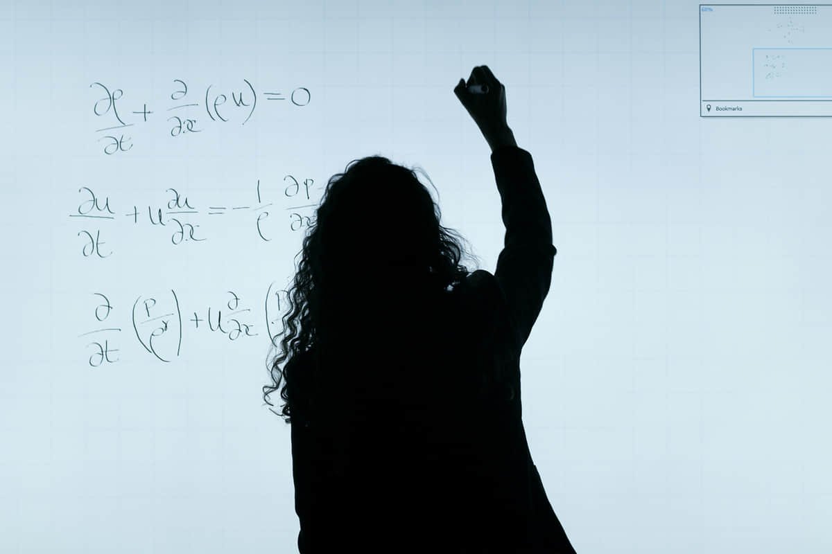 Woman analysing data and technical equipment inside a scientific workspace.